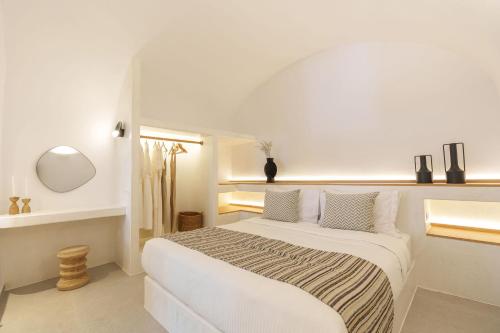 a white bedroom with a large white bed with pillows at Villa Karterados Suites in Karterados