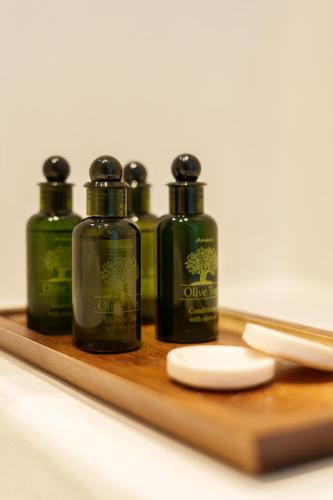 a group of four bottles on a wooden cutting board at Villa Karterados Suites in Karterados