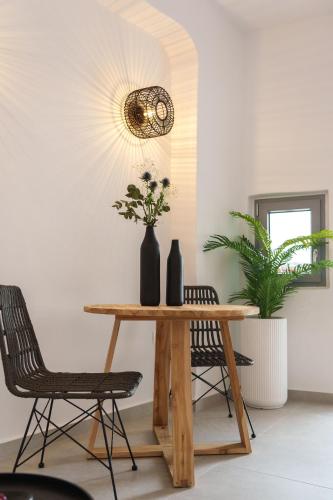 a dining room with a table and chairs and a chandelier at Villa Karterados Suites in Karterados
