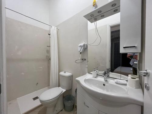 a white bathroom with a toilet and a sink at KiMia Home, Puglia in Modugno