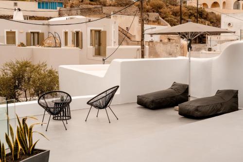 a patio with two chairs and chairs on a building at Villa Karterados Suites in Karterados