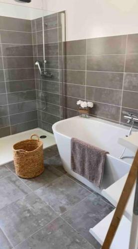 une salle de bain avec une baignoire et une douche et un panier dans l'établissement Villa moderne, à Gaujac