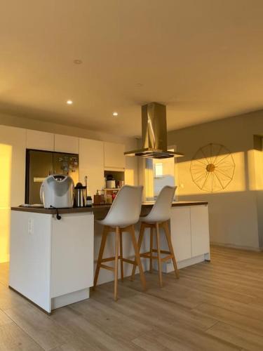 - une cuisine avec des armoires et des chaises blanches dans la chambre dans l'établissement Villa moderne, à Gaujac