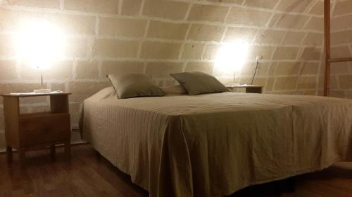 a bedroom with a bed with two lamps on two tables at Nel Vicoletto in Ginosa