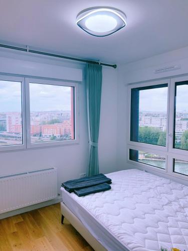 une chambre avec un lit et deux fenêtres dans l'établissement Vu Seine Appartement Duplex, à Ivry-sur-Seine