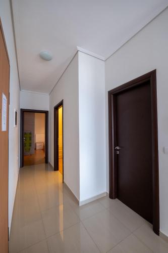 a hallway with white walls and a black door at Franklin Rooms in Sarandë