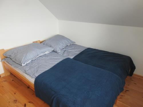 a bed with blue sheets and pillows in a bedroom at Dom nad jeziorem in Sorkwity