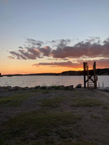 a wooden structure sitting on the shore of a body of water at Trevligt fritidshus med allt vad Bohuslän erbjuder in Fjällbacka