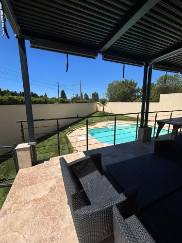 un patio avec une table et des chaises et une piscine dans l'établissement Magnifique villa pour le festival d'Avignon, à Avignon