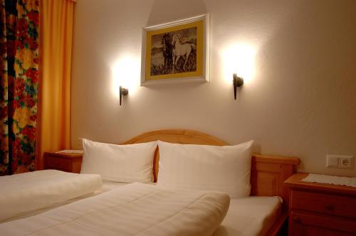 a hotel room with two beds with white pillows at Gasthof Neumeister in Stumm