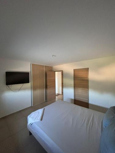 une chambre avec un lit et une télévision à écran plat dans l'établissement Magnifique villa pour le festival d'Avignon, à Avignon