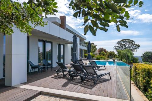 an outdoor deck with chairs and a swimming pool at Casa da Colina in Caldas de Monchique