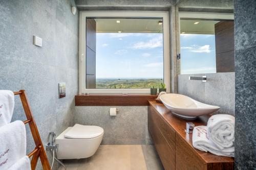 a bathroom with a sink and a toilet and a window at Casa da Colina in Caldas de Monchique