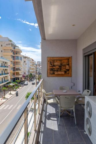 a balcony with a table and chairs and a street at Franklin Rooms in Sarandë