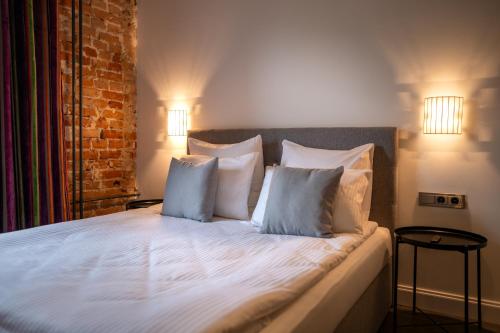 a bedroom with a bed with white sheets and pillows at Turgaus Self Check-in Old Town Aparthotel in Klaipėda