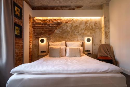 a bedroom with a bed with two lights on the wall at Turgaus Self Check-in Old Town Aparthotel in Klaipėda