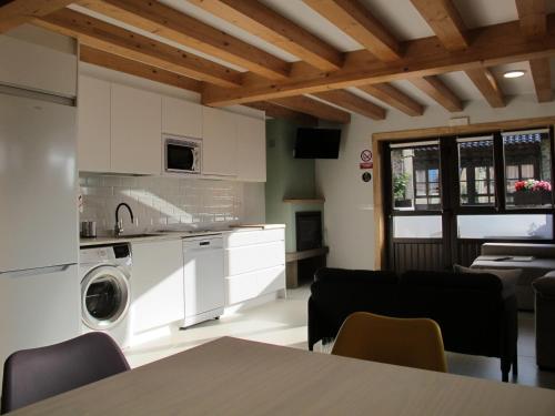 a kitchen and living room with a table and chairs at Casa Vacacional La Pedrera in Baró