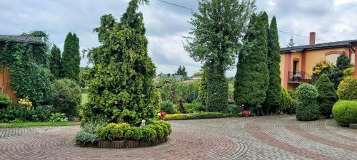 a garden with trees and flowers and a building at Dom Pod Gruszą in Chmielno