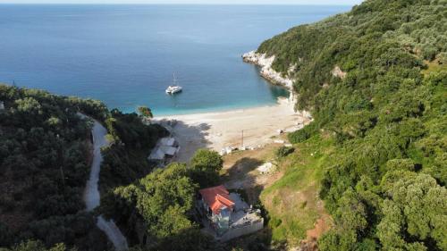 a boat in the water next to a beach at Limnionas Apartments in Xorychti