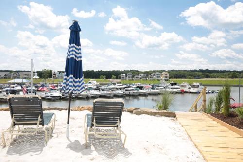 two chairs and an umbrella on the beach with a marina at Out of Office in Ottawa
