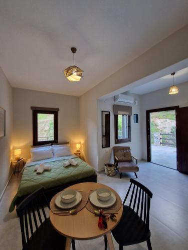 a bedroom with a bed and a table and chairs at Limnionas Apartments in Xorychti