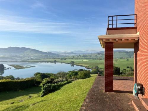 a brick building with a view of a lake at Casa con piscina en Ajo - Las Arrañadas in Bareyo