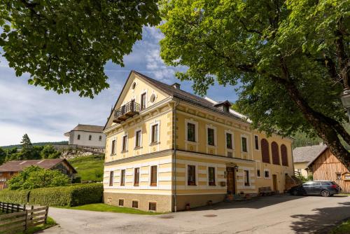 a large yellow building with a balcony on top of it at Haus König in Mauterndorf