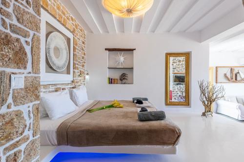 a bedroom with a large bed and a stone wall at Onar Suites & Villas in Karavostasi