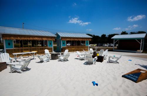 a group of chairs and tables in the sand in front of a building at Just a Little Longer in Ottawa