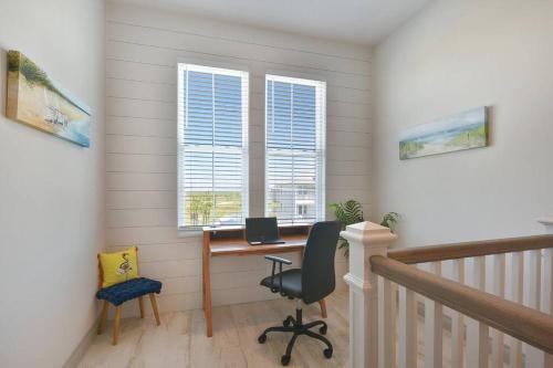 a home office with a desk and two windows at Rise and Shine Beach House with Ocean Views and Pointe West Resort Pools in Galveston