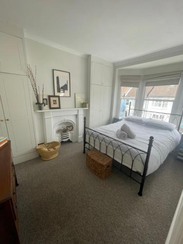 a bedroom with a bed and a fireplace and a window at Poets Place - lovely 4 bedroom townhouse with garden in Brighton & Hove