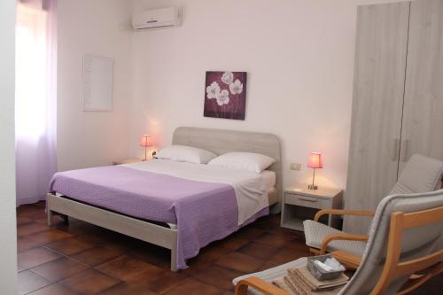 a bedroom with a bed and a chair in it at B&B Villa Adriana in San Leone