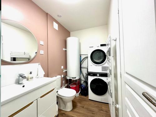 a bathroom with a washer and dryer in it at L'Équinoxe - Parking privé - Zapart'Hôtels in Malesherbes
