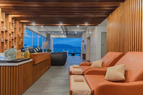 a living room with orange furniture and a view of the ocean at Le's Cham Hotel in Nha Trang