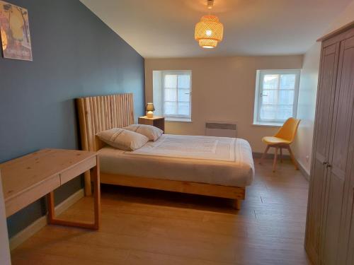 une chambre avec un lit et une table et deux fenêtres dans l'établissement Marennes - Duplex cœur de village, à Marennes