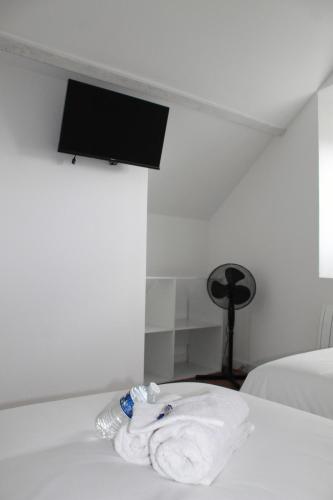 a pile of towels sitting on top of a bed at L'Équinoxe - Parking privé - Zapart'Hôtels in Malesherbes