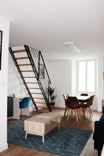 a living room with a staircase and a table and chairs at L'Équinoxe - Parking privé - Zapart'Hôtels in Malesherbes