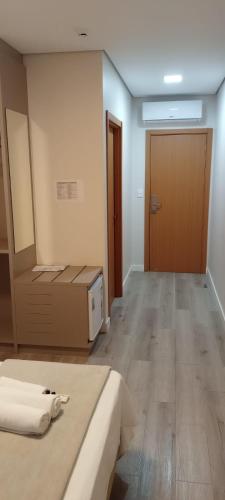 a room with a bed and a wooden door at HOTEL CALIFÓRNIA in Concordia