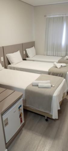 a room with two beds and avertisement at HOTEL CALIFÓRNIA in Concordia