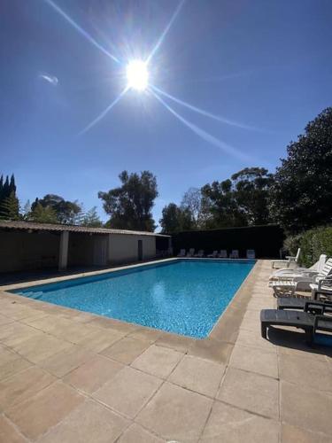 - une piscine avec des chaises et le soleil dans le ciel dans l'établissement 1 Bed Antibes les pins with Pool, à Antibes