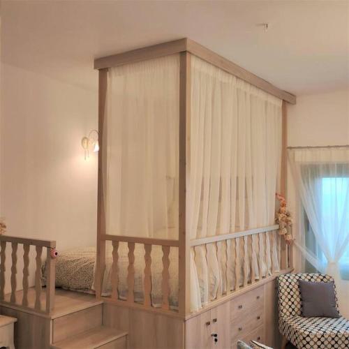 a baby crib with a canopy in a room at Laurel LK Houses in Kritinia Rhodes in Kritinía