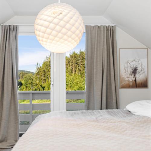 a bedroom with a bed and a large window at Gårdsferie nær Bø i Telemark Sommarland in Norem