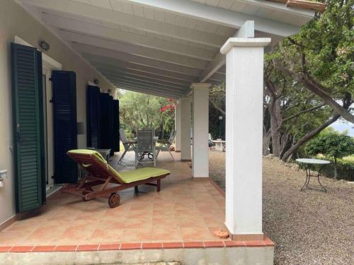 a patio with a table and a chair on a house at Secluded seaside villa w garden sea-sunset view in Korakokhórion