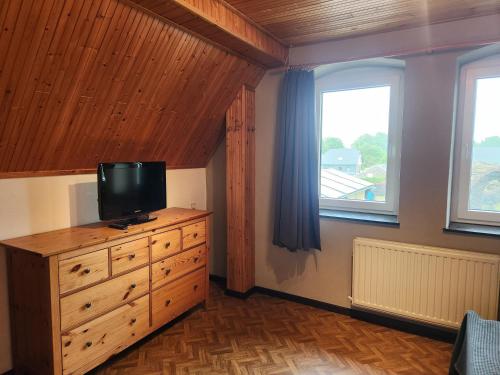 a bedroom with a dresser with a television on it at Appartement Schlanser in Waimes