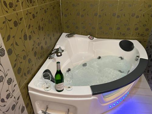 a bath tub with a bottle of wine and two glasses at Casa La Oliva Vejer in Vejer de la Frontera