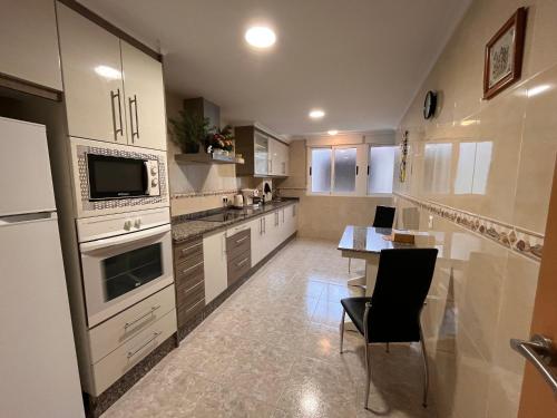 cocina grande con mesa y microondas en Manda Pola, en Santa Pola