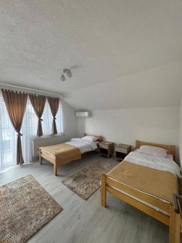 a bedroom with two beds and two rugs at BORIĆI in Bihać