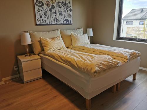 a bed in a bedroom with a window and a bed sidx sidx sidx at New and fresh apartment, free parking and ocean view in Trondheim
