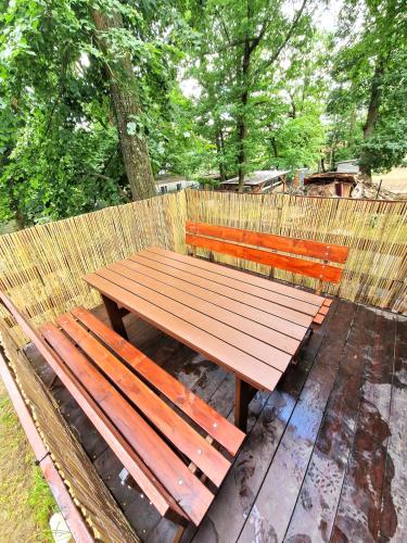 a wooden bench sitting in front of a fence at Chata Vranovská pláž in Štítary