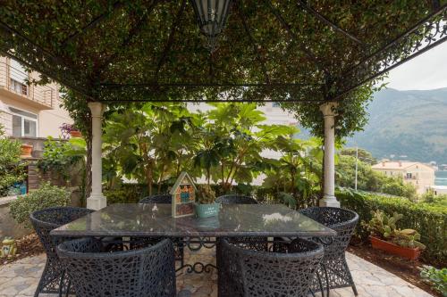 a patio with a table and chairs under a pergola at Vučković Studios in Kotor